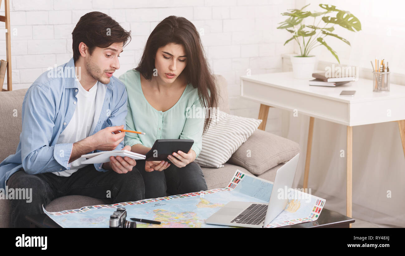 Couple counting finances for vacation, planning journey Stock Photo