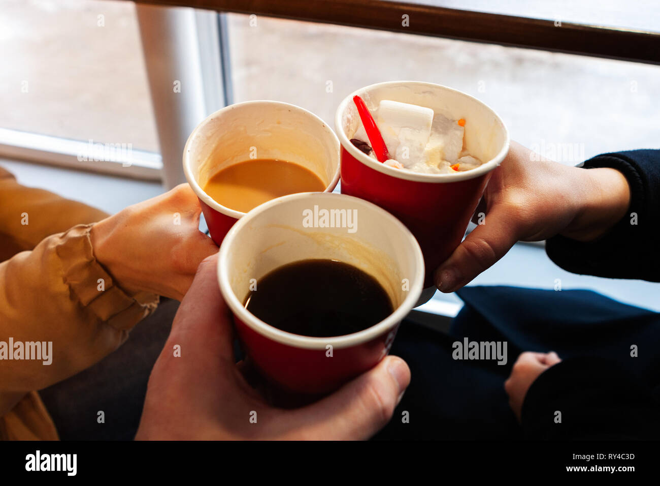 close up hands with coffee cups at cheers time. friends have fun and drink  coffee in the cafeteria Stock Photo - Alamy