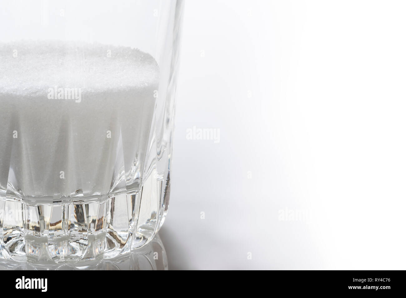 Granulated sugar in a glass tumbler. Stock Photo