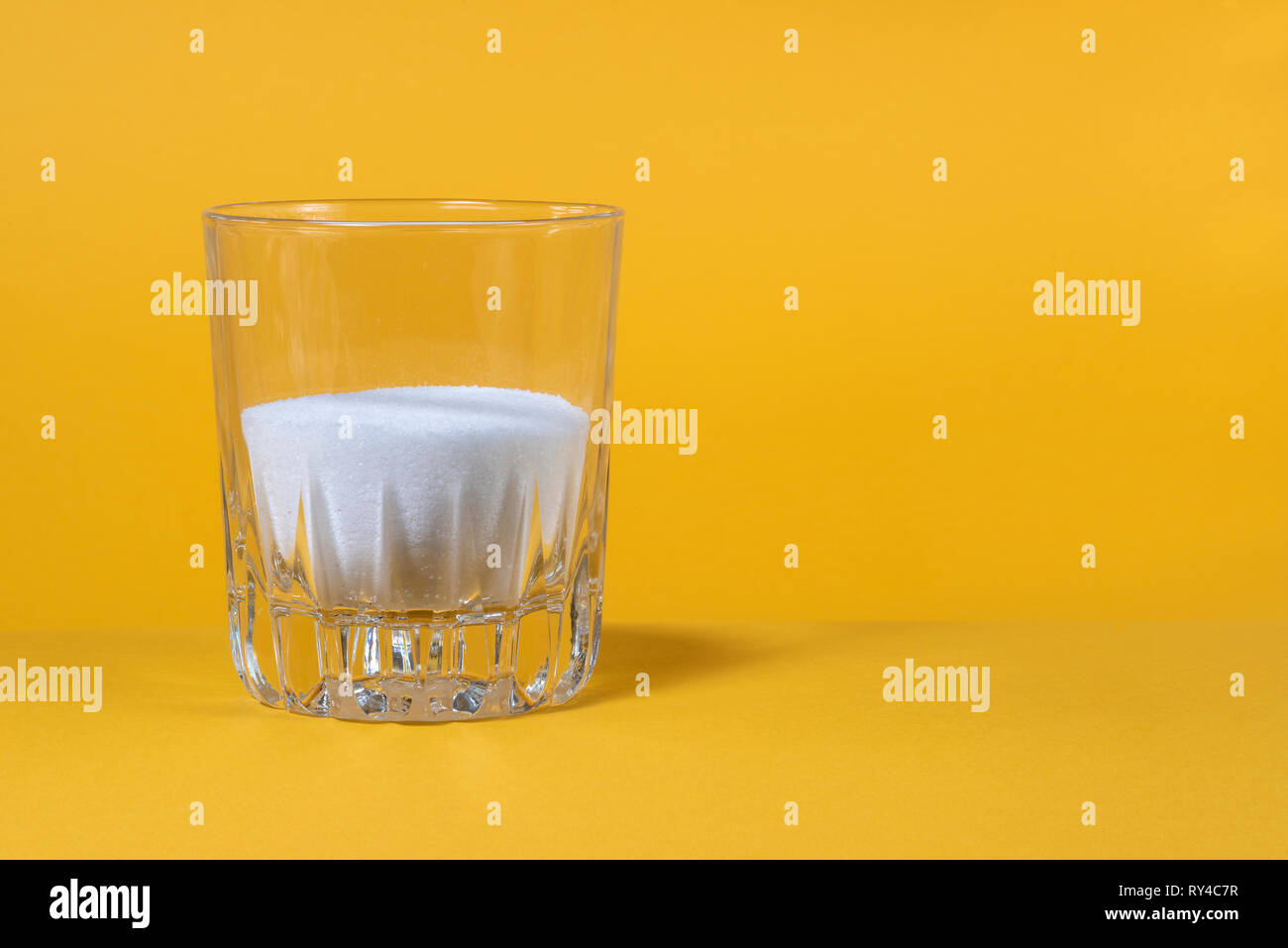 Granulated sugar in a glass tumbler. Stock Photo