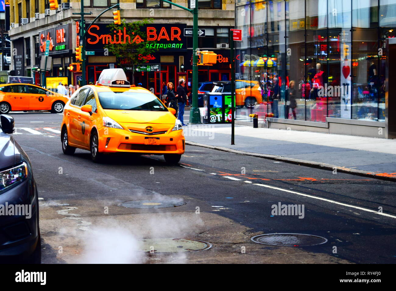 new york city yellow taxi - midtown / hell's kitchen with famous bar in background.2016 Stock Photo