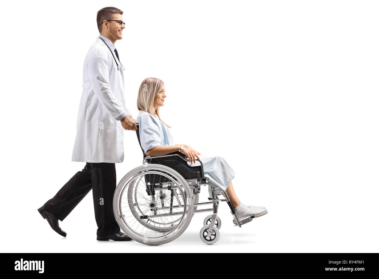 Full length shot of a young male doctor pushing a female patient in a wheelchair isolated on white background Stock Photo