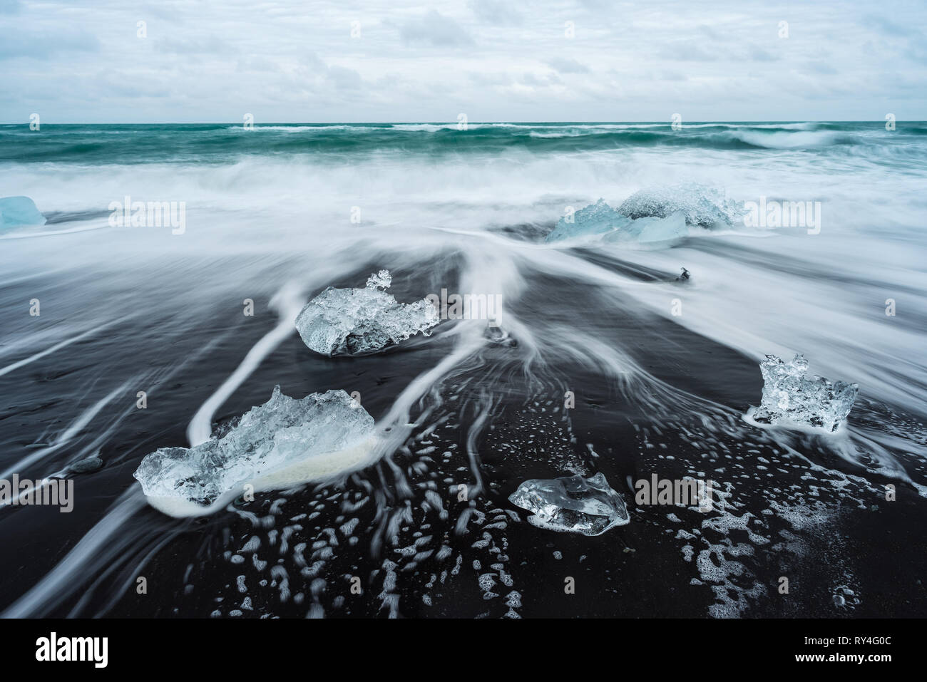 Icy beach in Iceland, Europe. Ice on the black volcanic sand on the Atlantic Ocean. Tourist attraction. Amazing landscape cloudy day. World beauty. Stock Photo
