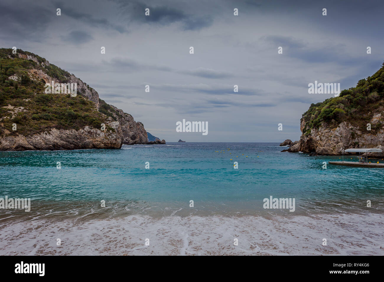 Paleokastritsa bay cliffs and beach with Kolyviri island background on a rainy day, Corfu Island, Greece Stock Photo