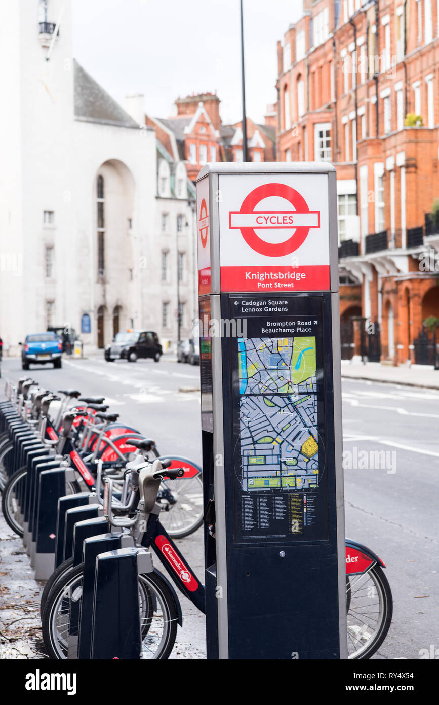 Santander bike docking station along with a map and payment tool on a quiet street side. Stock Photo