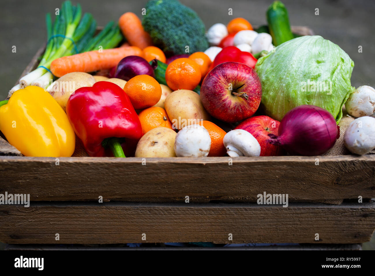 Fruit and vegetables. A vintage wooden crate filled with colourful fresh fruit and vegetables to promote healthy vegan plant based living. Stock Photo