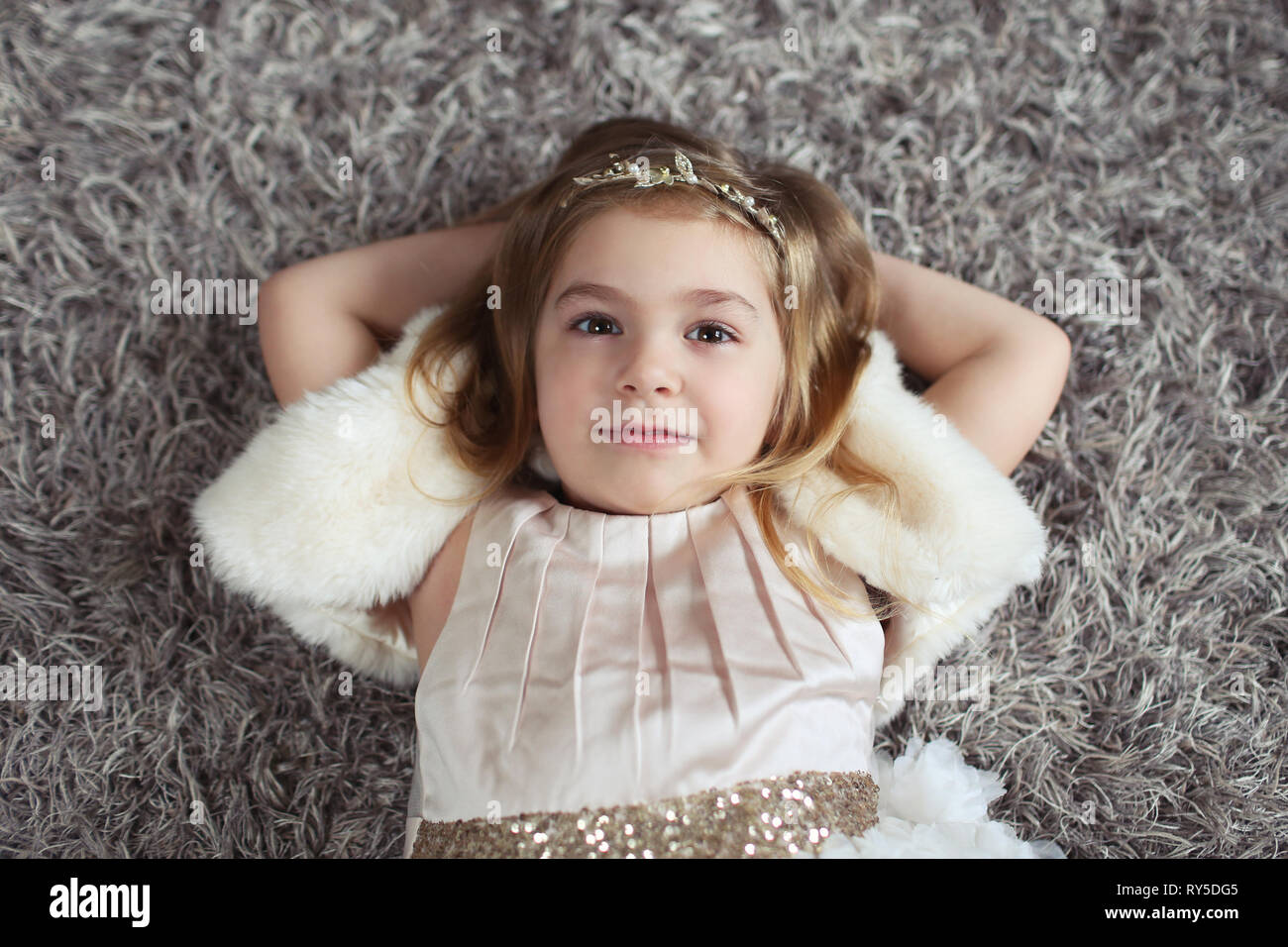 Little girl lay on floor and smile Stock Photo - Alamy