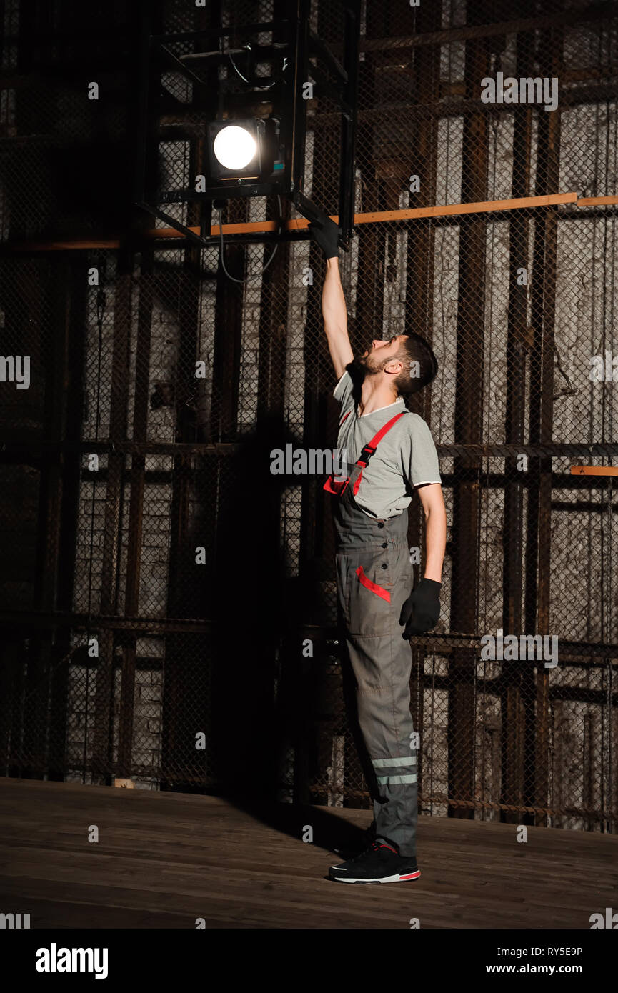 The lighting engineer adjusts the lights on stage behind the scenes