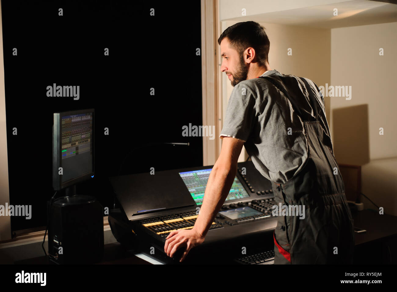 A lighting engineer works with lights technicians control on the concert show. Professional