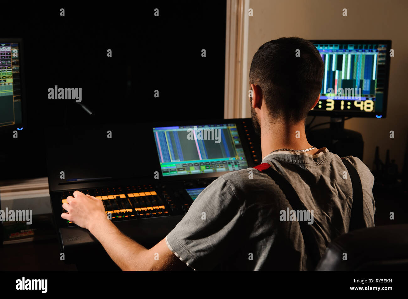 A lighting engineer works with lights technicians control on the