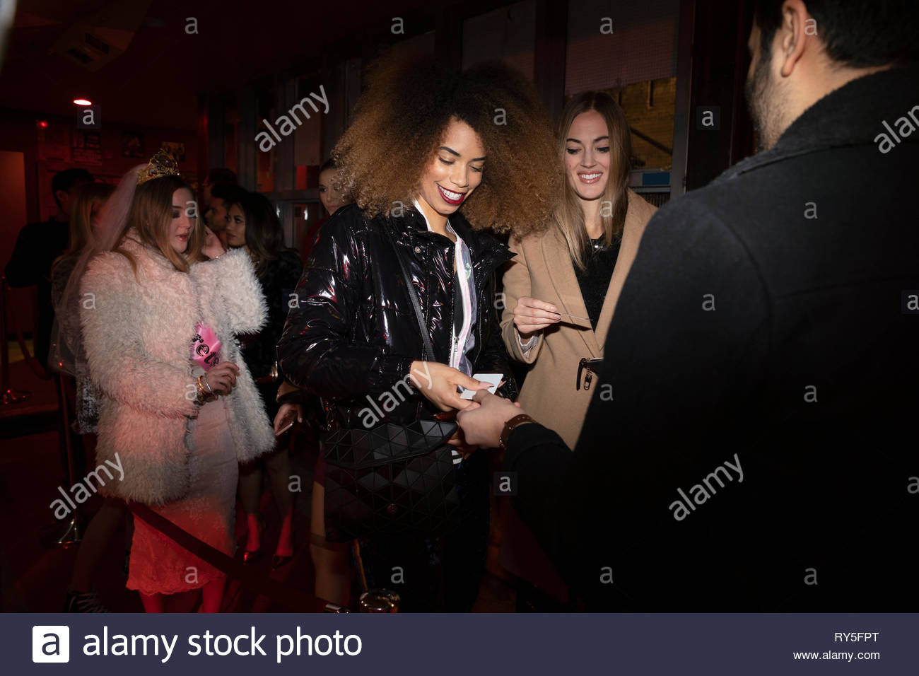 Women showing IDs to bouncer in queue Stock Photo Alamy