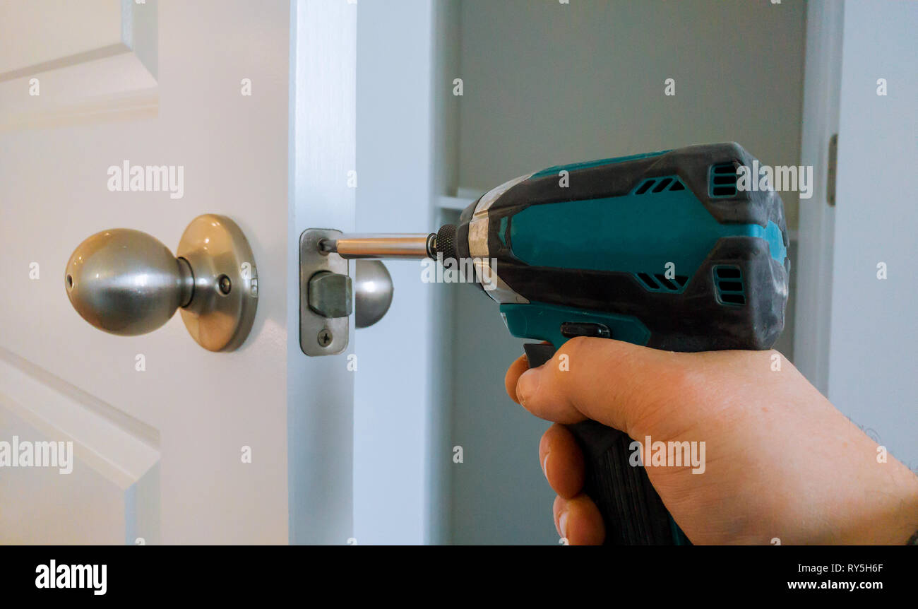 Hands repairing a door lock with a screwdriver Stock Photo Alamy