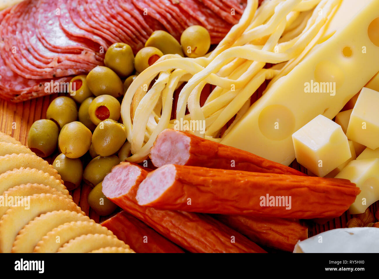 meat and cheese tray wheat crackers, summer sausage, cheddar cheese, a