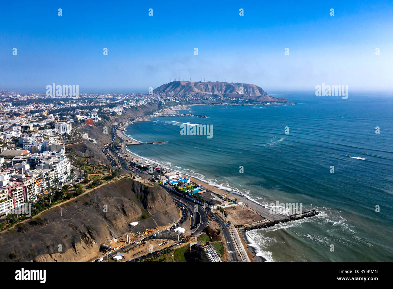 Aerial view of Lima's shoreline including the districts of Barranco and Chorrillos, with 'Morro Solar' on the background. Clear and bright day, travel Stock Photo