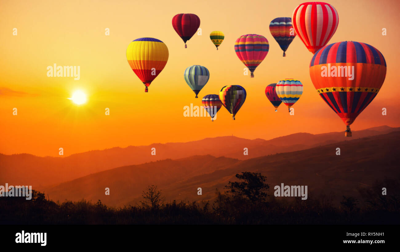 Blur of image hot air balloon above high mountain at sunset Stock Photo -  Alamy