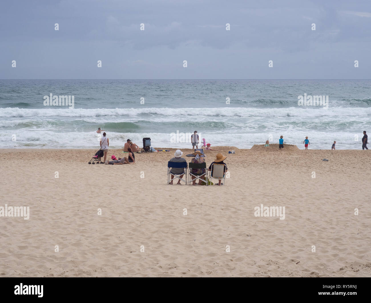 People Sitting In Beach Chairs On The Beach Stock Photo