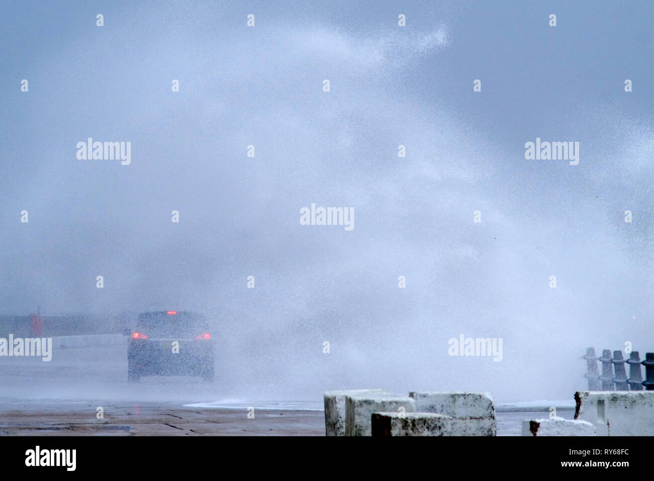 Newhaven, East Sussex, UK. 12th Mar, 2019. Giant waves dwarf the lighthouse at Newhaven Harbour, East Sussex, as storm Gareth brings wild weather to the UK. Credit: Peter Cripps/Alamy Live News Stock Photo
