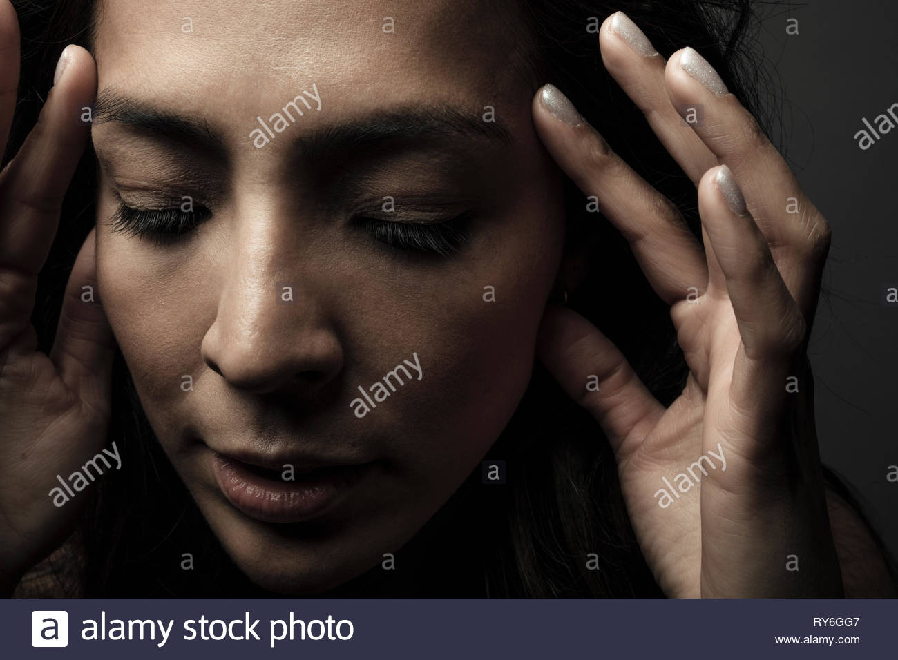Woman head in hands looking down hires stock photography and images