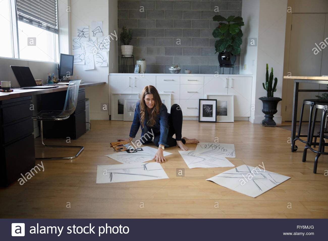 Female artist sketching on floor in studio Stock Photo