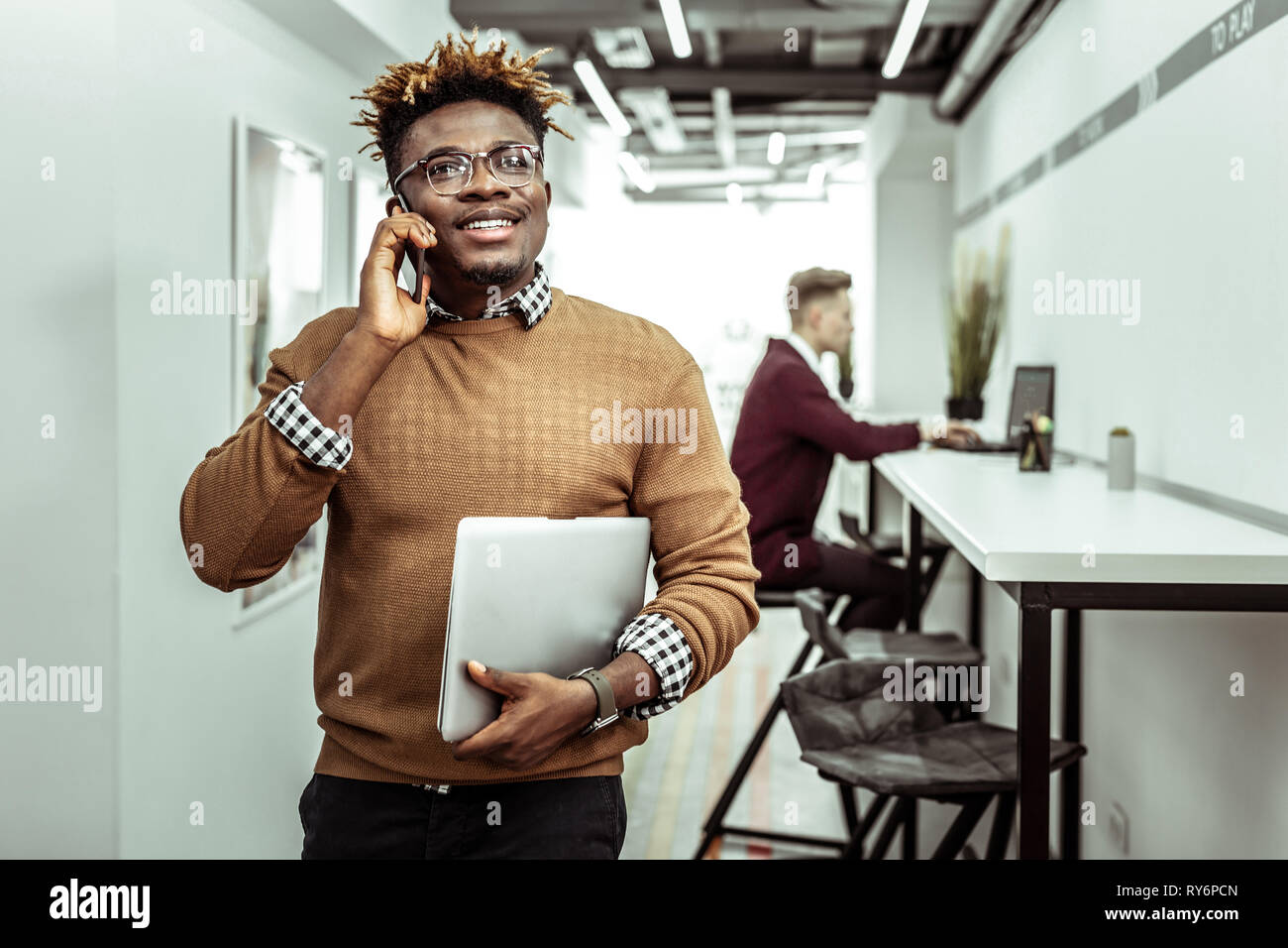Smiling guy having pleasant conversation while going on break Stock Photo
