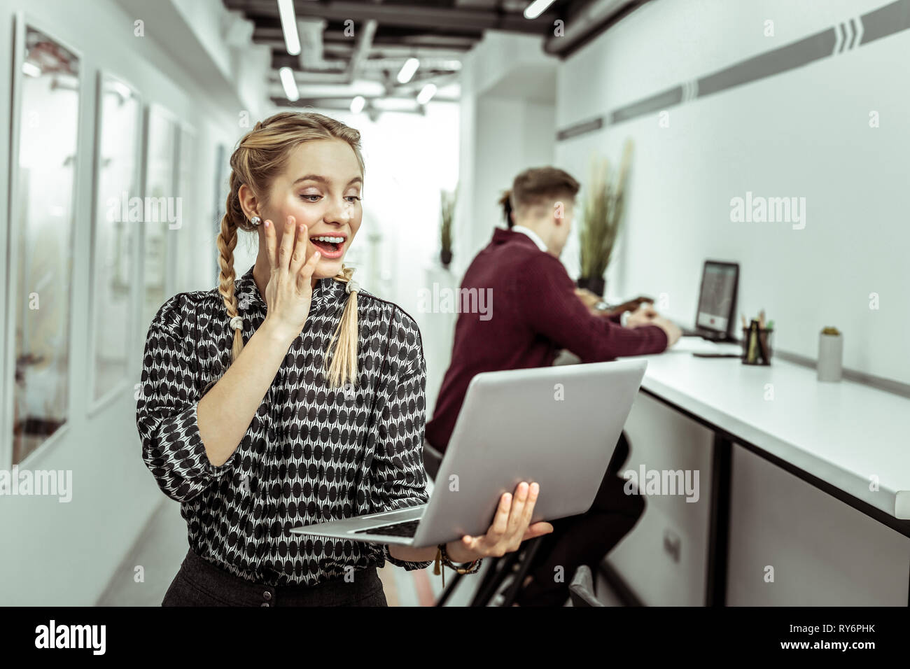 Surprised light-haired female office worker being expressive during conversation Stock Photo