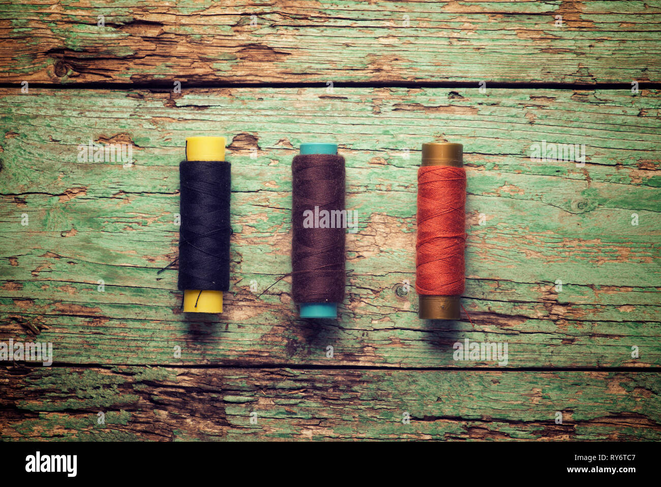 Overhead view of colorful threads on old wooden table Stock Photo