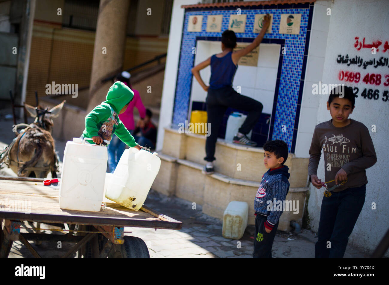 Palestinian children are seen fetching water at the Bureij refugee camp, south of the Gaza Strip. More and more Gazans are falling ill from their drinking water, highlighting the humanitarian issues facing the Palestinian enclave that the UN says could become uninhabitable by 2020. Stock Photo