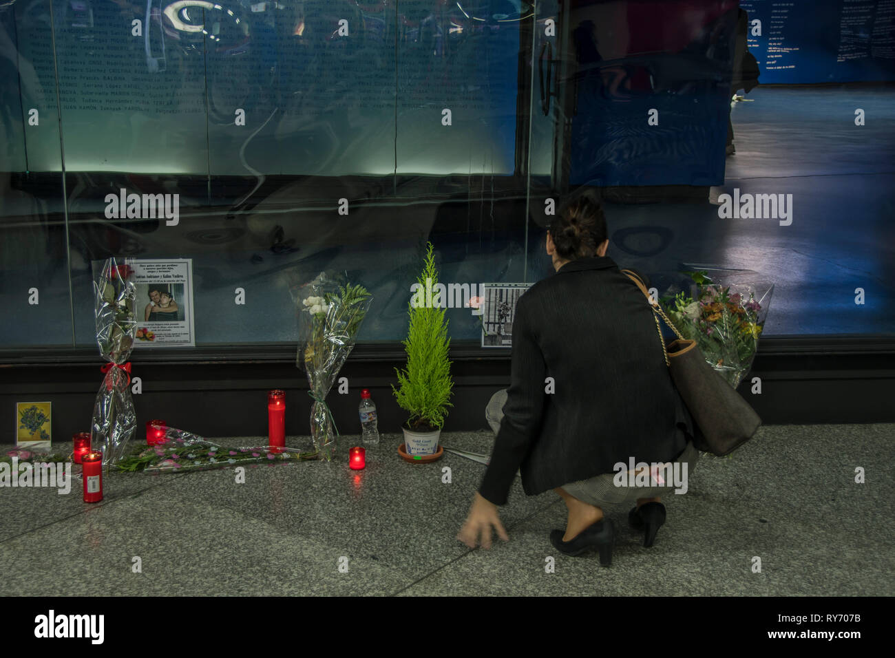 A woman seen holding wreath flowers during a tribute of those affected by the terrorist attack in 2004. Homage to the victims of 11 terrorism attack 2004 at the atocha train station in Madrid, Spain. Stock Photo