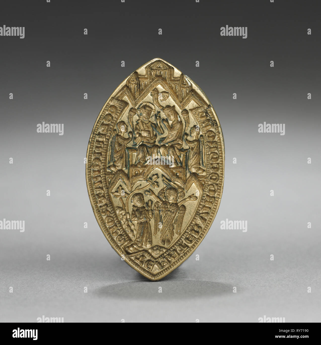 Almond-Shaped Seal: Coronation of the Virgin with a Kneeling Monk, 1300s. England or Germany, Gothic period, 14th century. Gilded bronze; overall: 3.9 x 2.6 cm (1 9/16 x 1 in Stock Photo