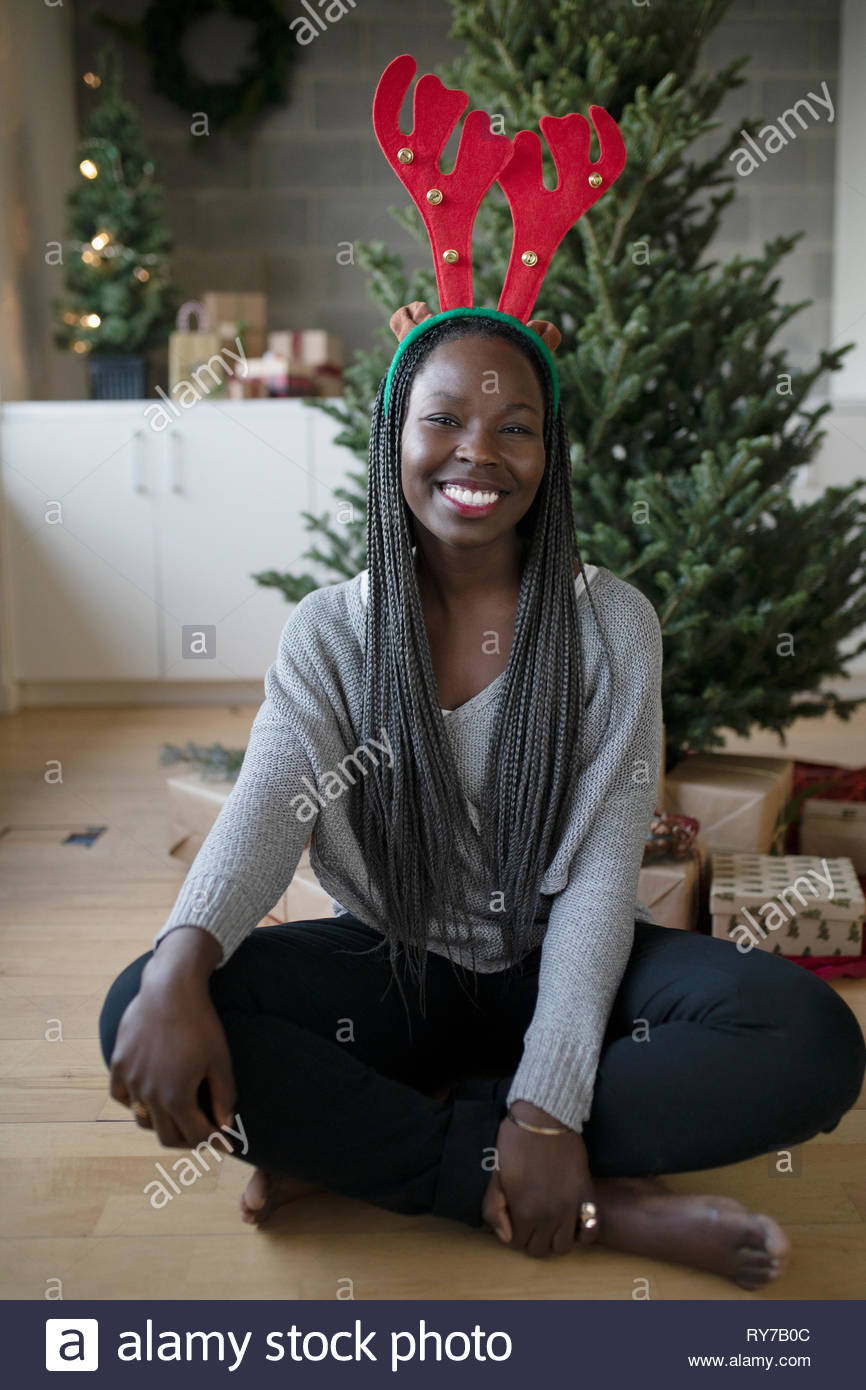 Portrait happy beautiful young African American woman wearing christmas reindeer antlers Stock Photo