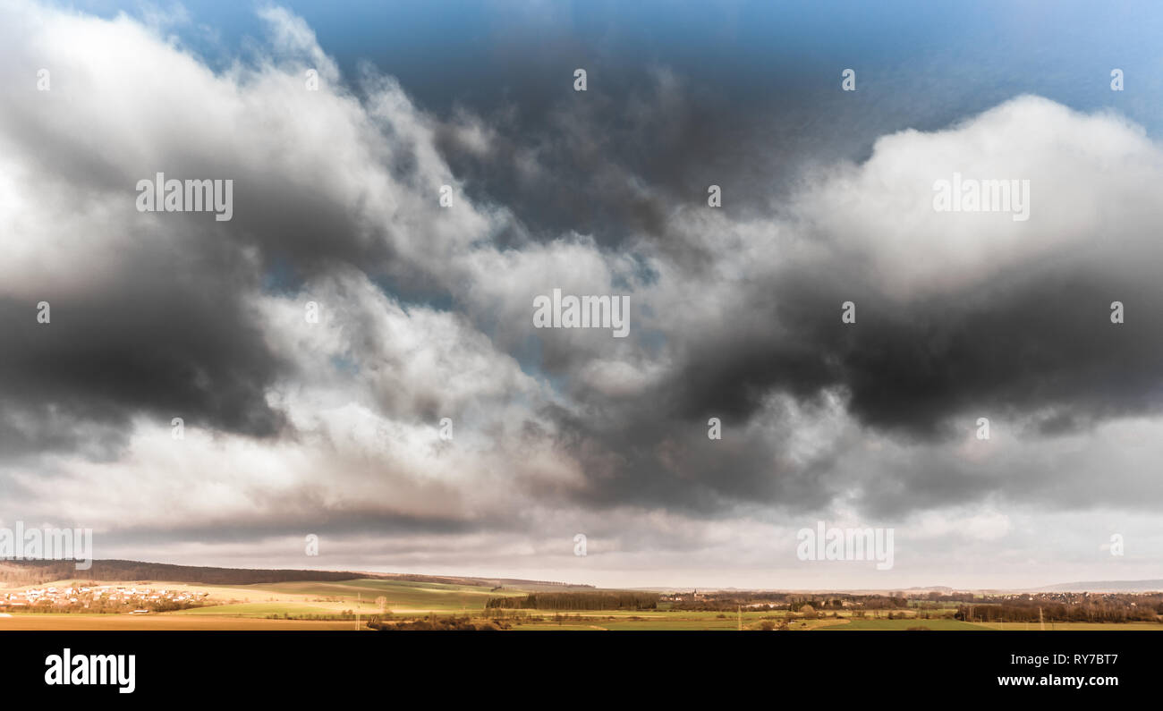 Dramatic sky with dark clouds over the hilly Harz foreland near the Oker, aerial photo with the drone Stock Photo