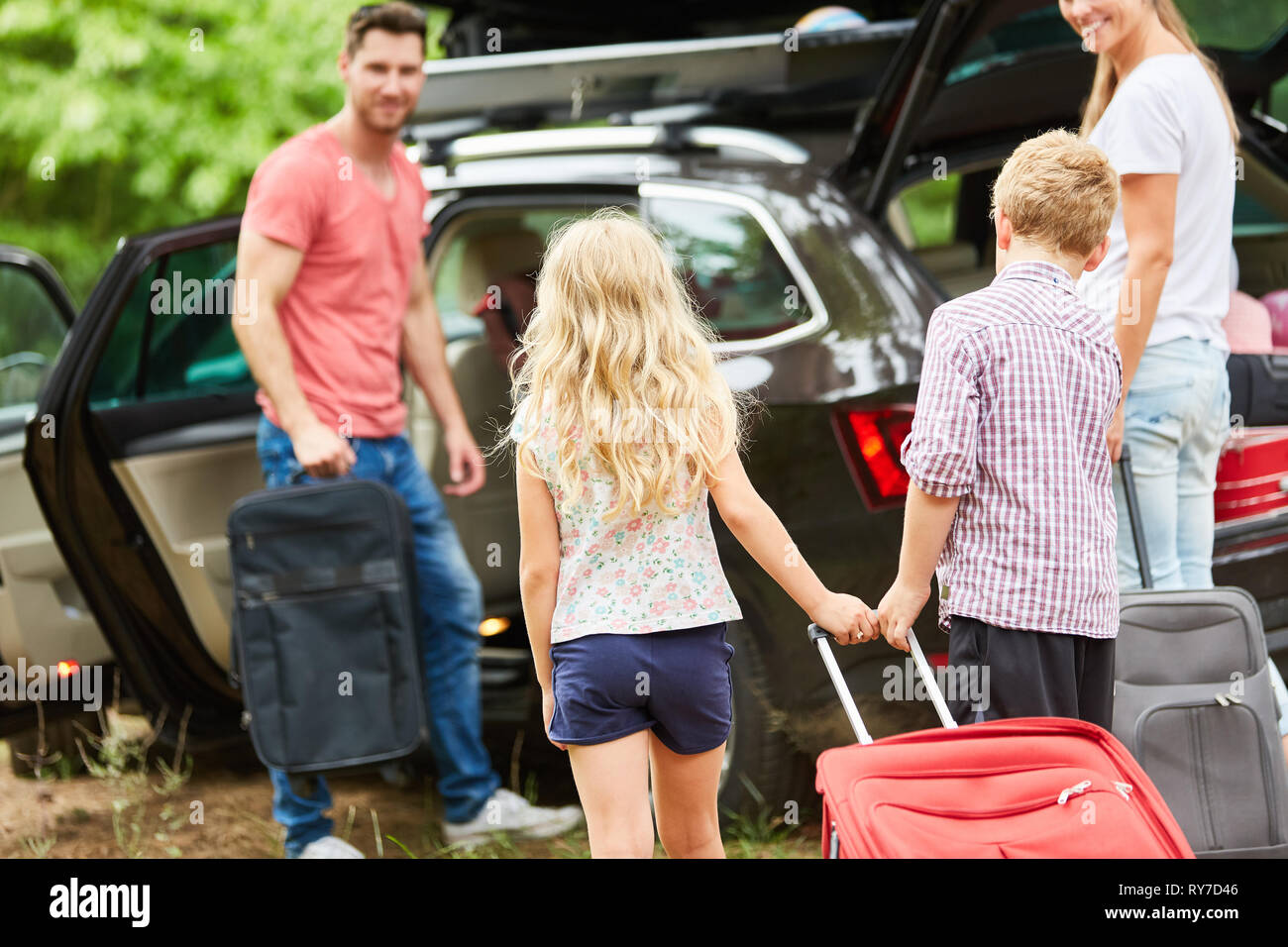 Family at the car packing at the suitcase before traveling on vacation Stock Photo
