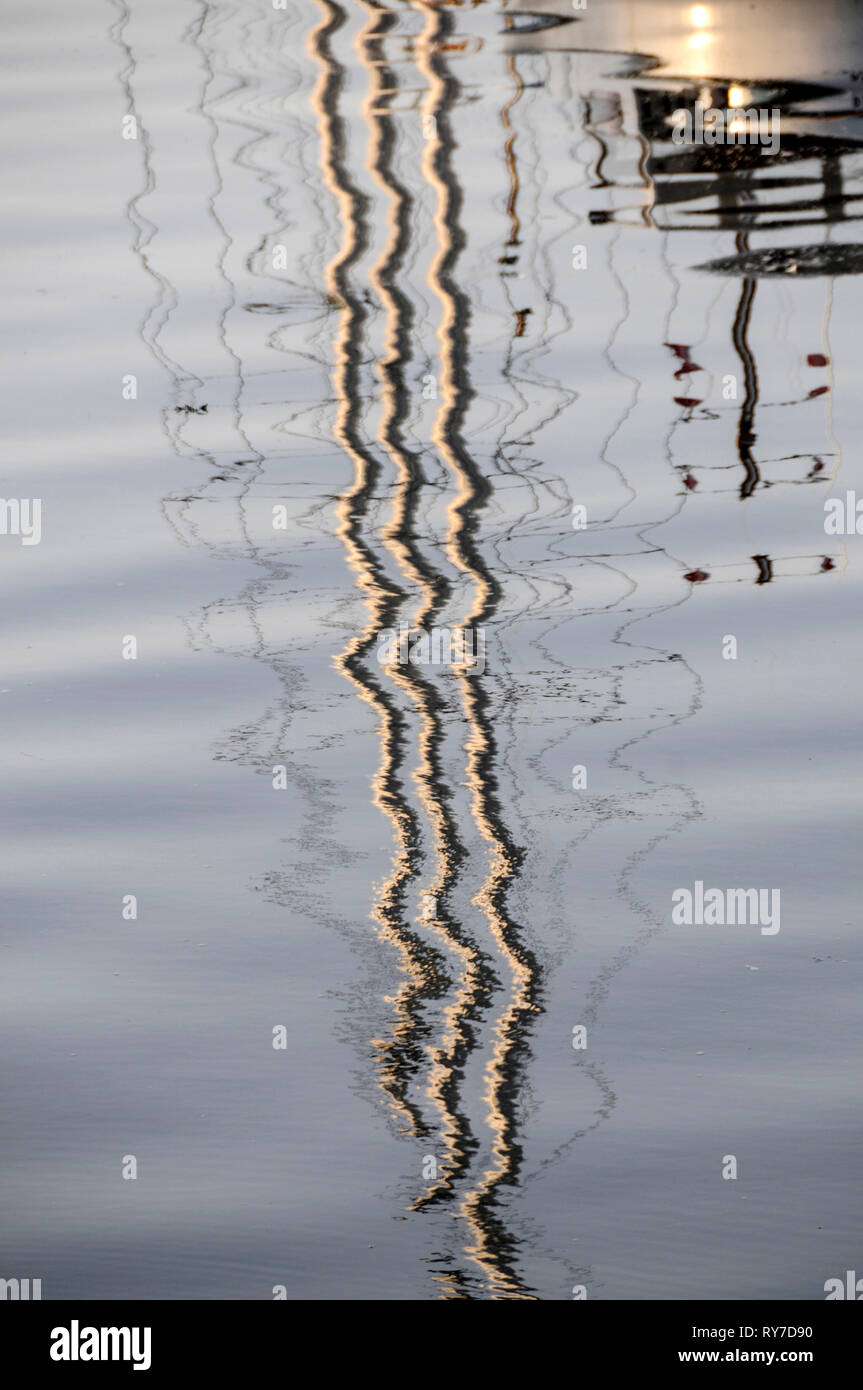 Water reflection of a  yacht's mast in the quay in a small town of Castletown on the south coast of the Isle of Man, Britain.   The Isle of Man with i Stock Photo