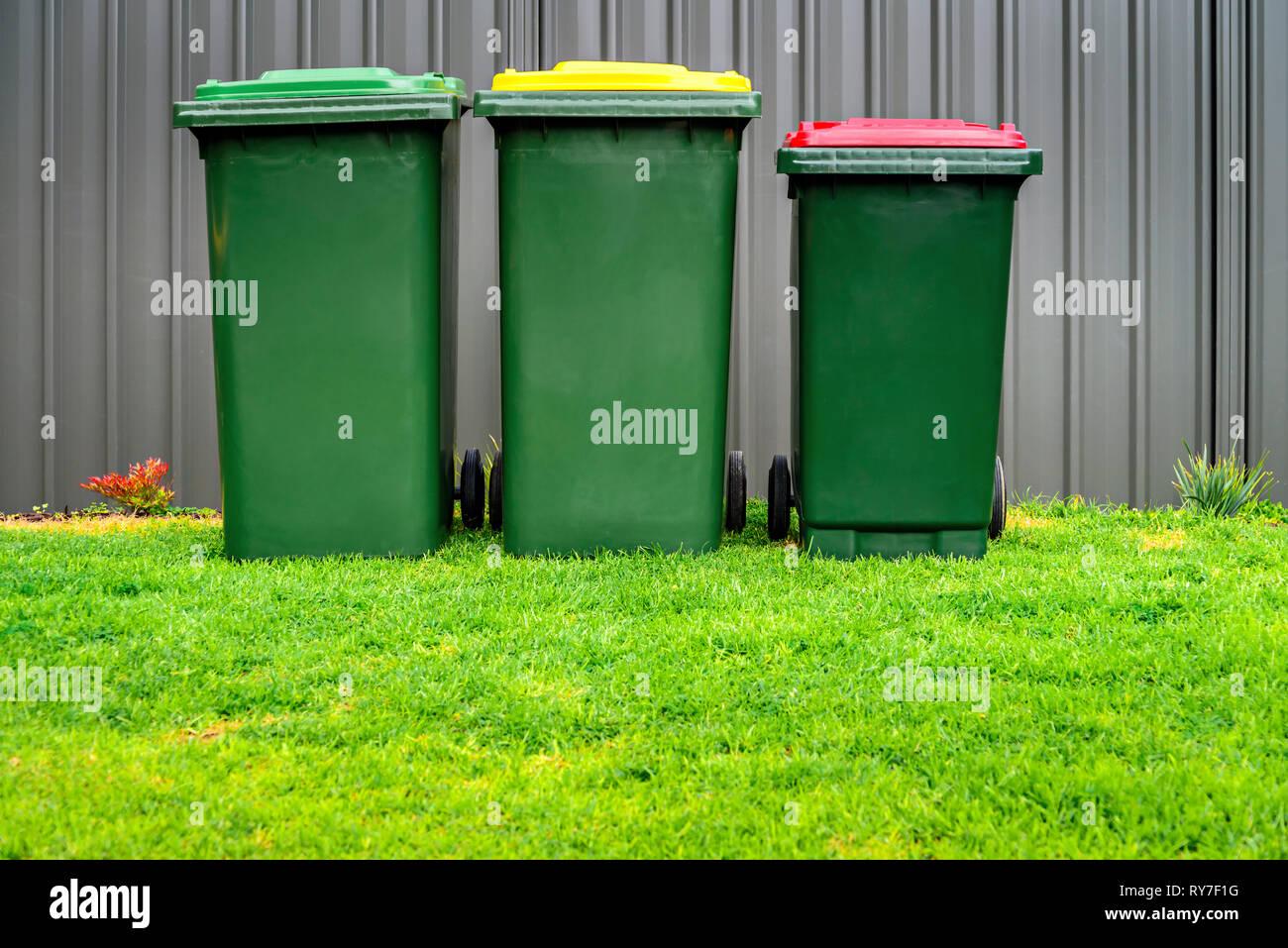 Australian home waste bins set provided by local council installed on backyard of suburbuan house Stock Photo