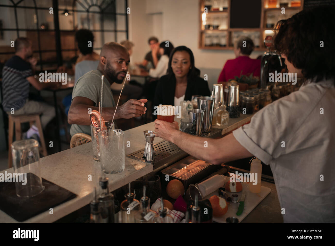 Young couple having drinks at a bar in the evening Stock Photo