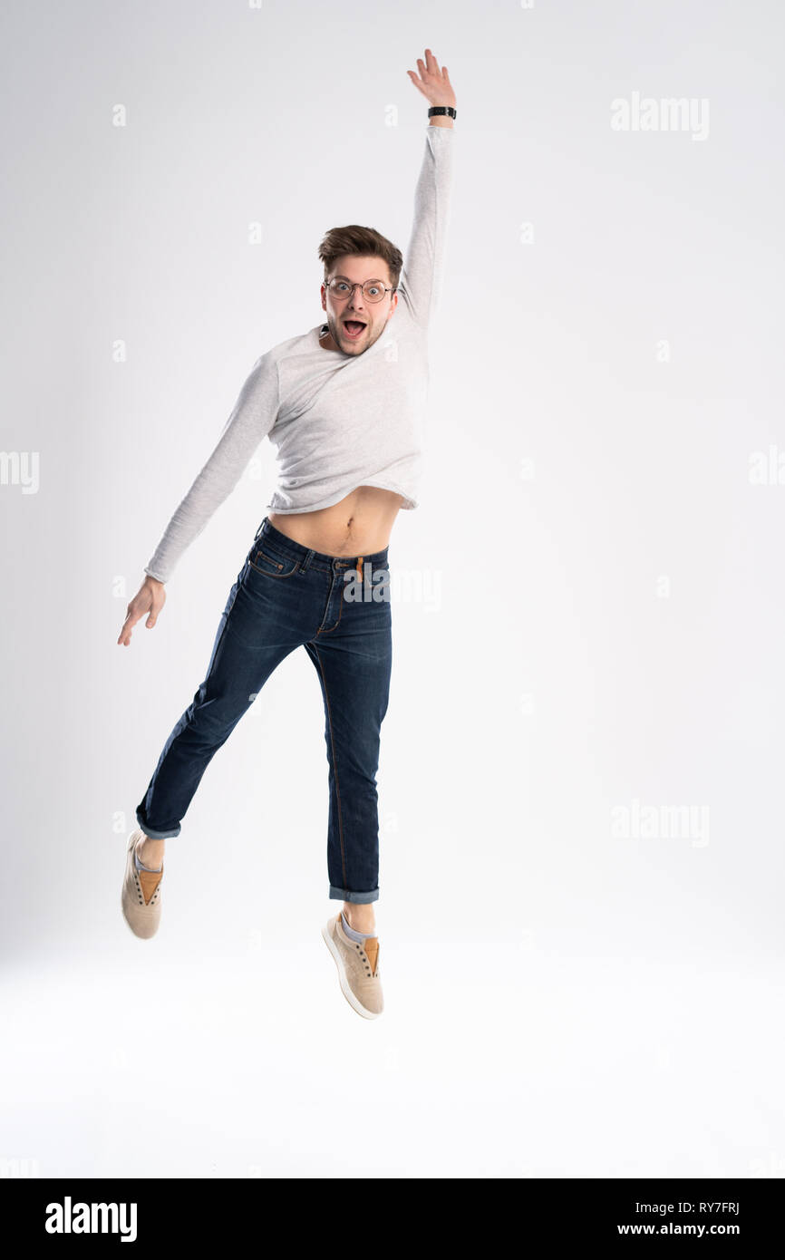 Full-length photo of funny man 30s in casual t-shirt and jeans jumping  isolated over white background Stock Photo - Alamy