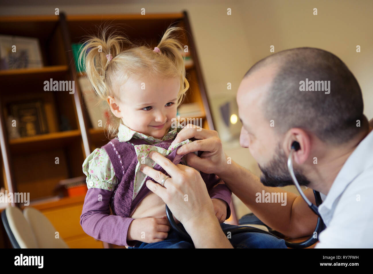 Doctor using a stethoscope to listen to a child's heartbeat Stock Photo