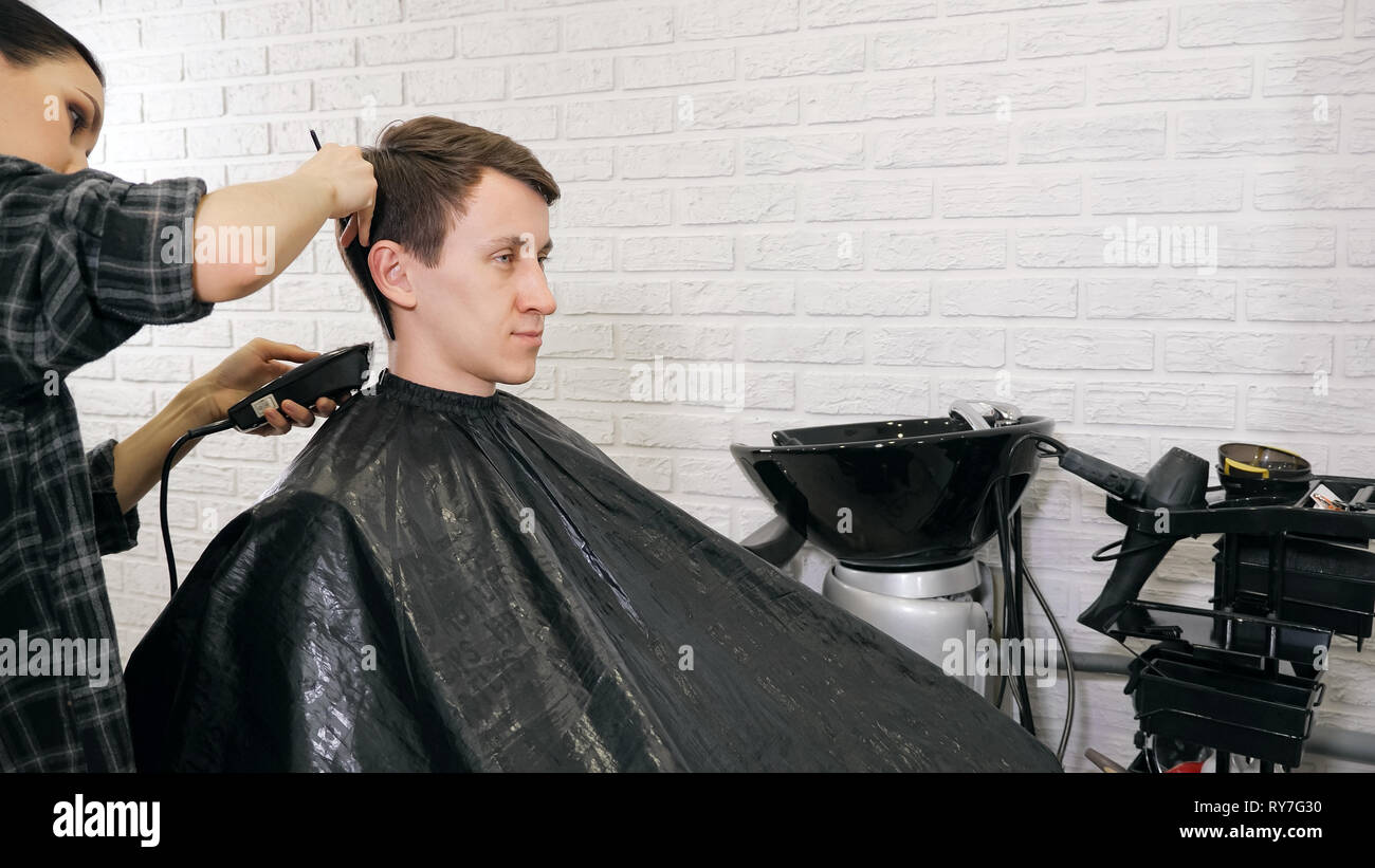 Female Barber Cutting Hair With Hair Trimmer Stock Photo