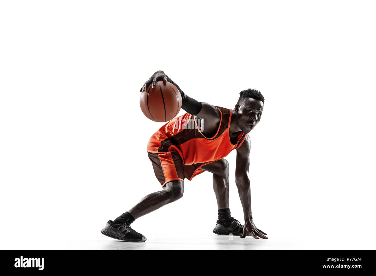 Full length portrait of a basketball player with a ball isolated on