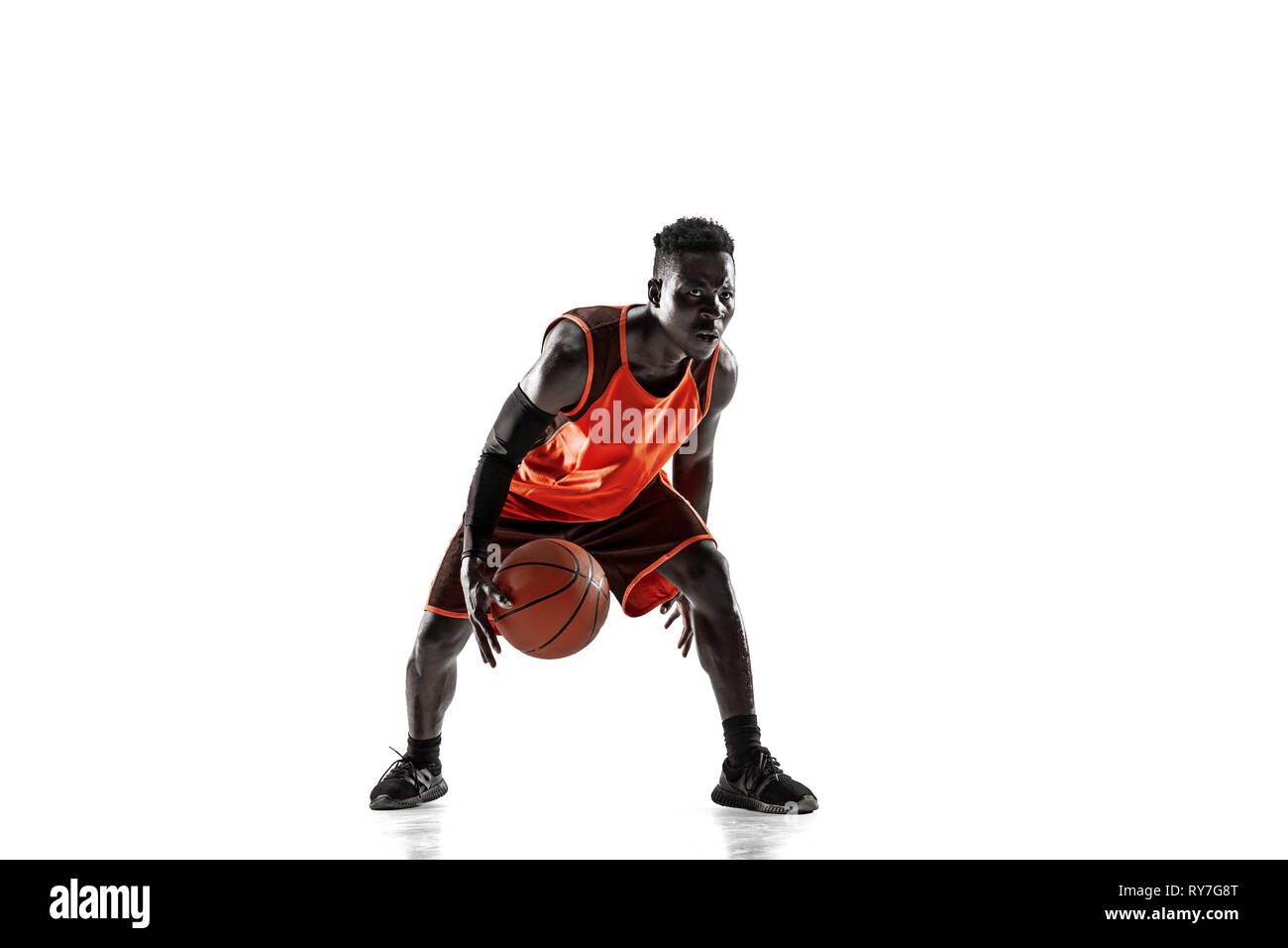 Full length portrait of a basketball player with a ball isolated on
