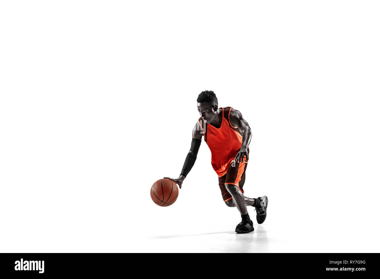 Full length portrait of a basketball player with a ball isolated on