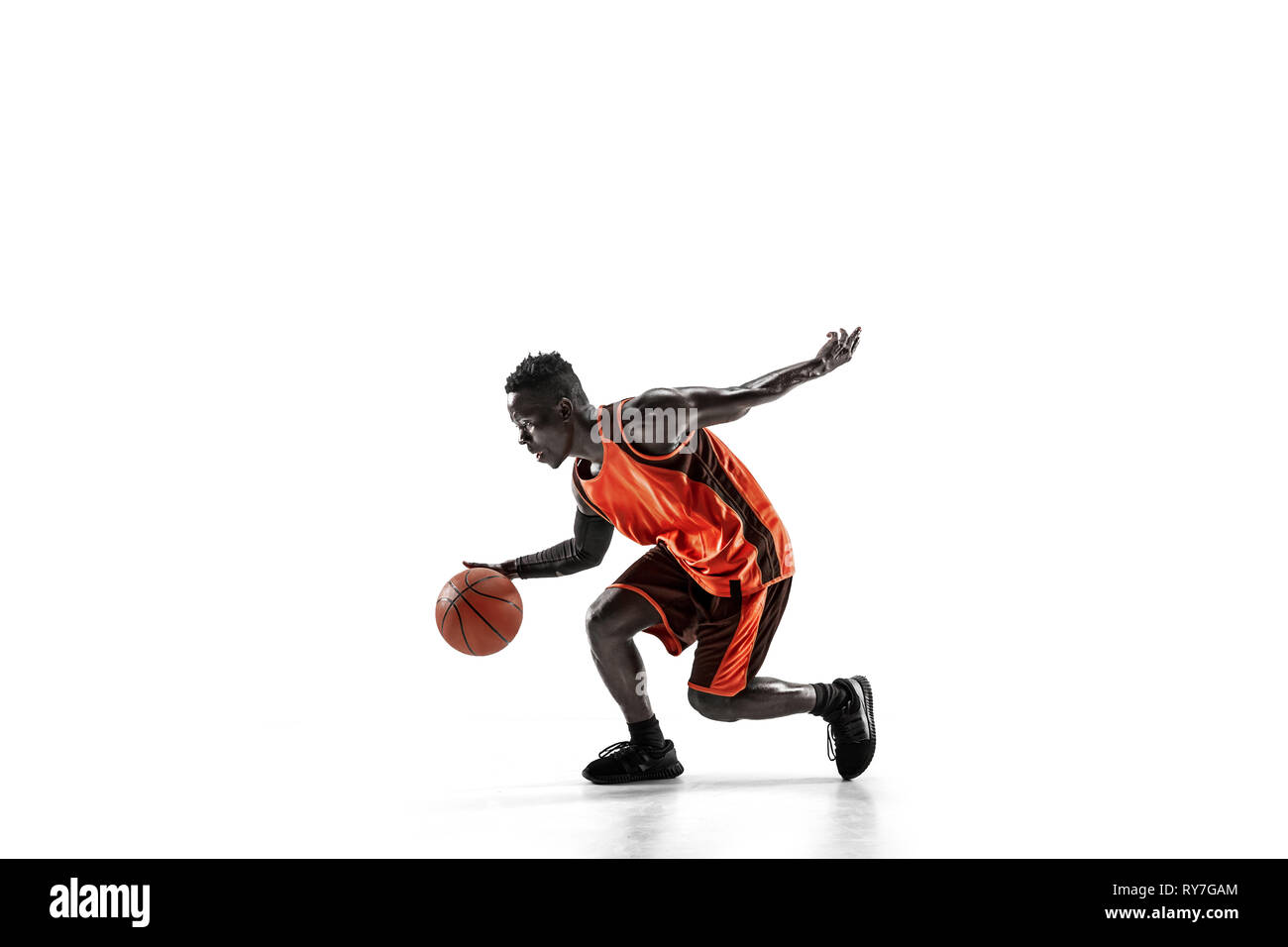 Full length portrait of a basketball player with a ball isolated on white studio background. advertising concept. Fit african anerican athlete with ball. Motion, activity, movement concepts. Stock Photo