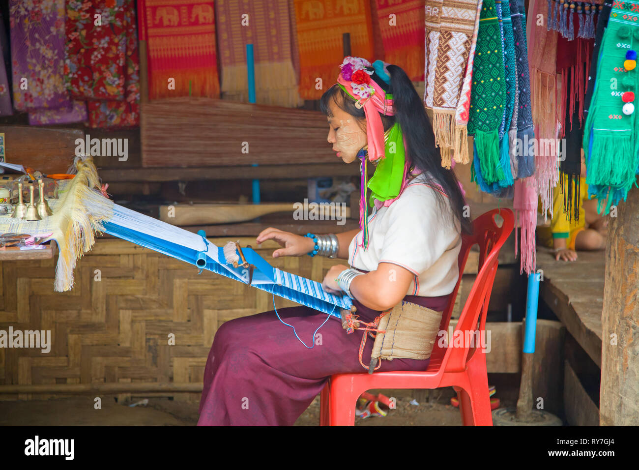 Kayan woman in traditional clothing weaving by hand fabric on a hand loom. Ban Huai Seau Tao village NV Thailand (Mae Hong Son). Thailand. Stock Photo