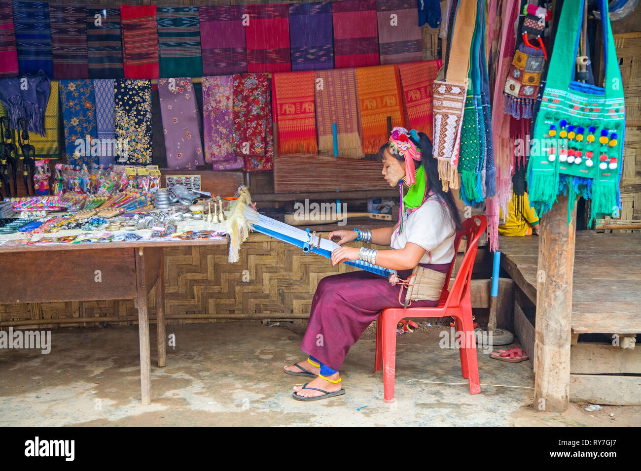 Kayan woman in traditional clothing weaving by hand fabric on a hand loom. Ban Huai Seau Tao village NV Thailand (Mae Hong Son). Thailand. Stock Photo
