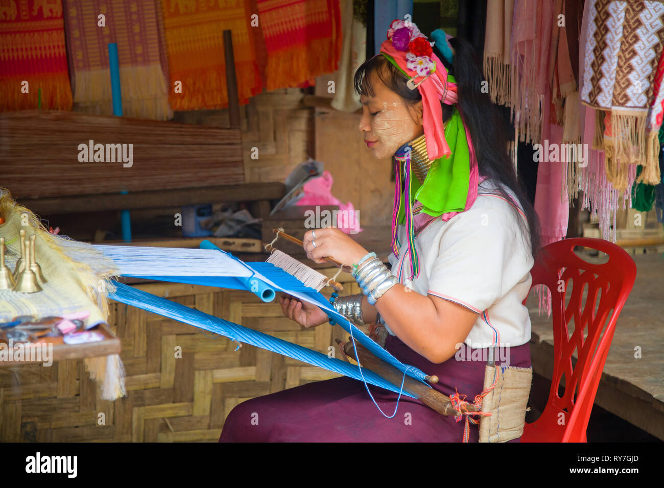 Kayan woman in traditional clothing weaving by hand fabric on a hand loom. Ban Huai Seau Tao village NV Thailand (Mae Hong Son). Thailand. Stock Photo