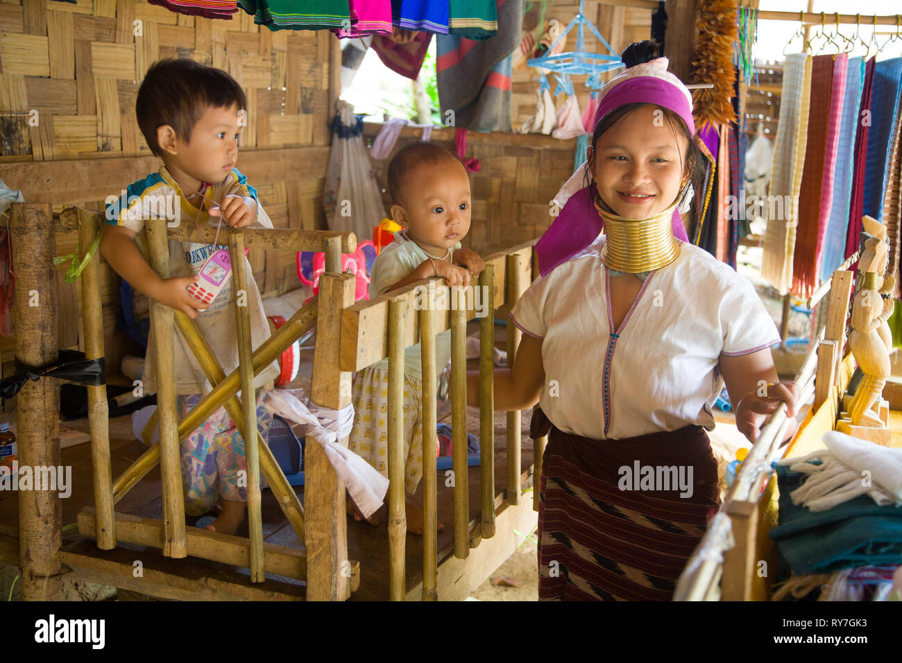 Portrait of Kayan woman with children inside the house. Ban Huai Seau Tao village NV Thailand (Mae Hong Son). The Kayan are a group of the Karen peopl Stock Photo