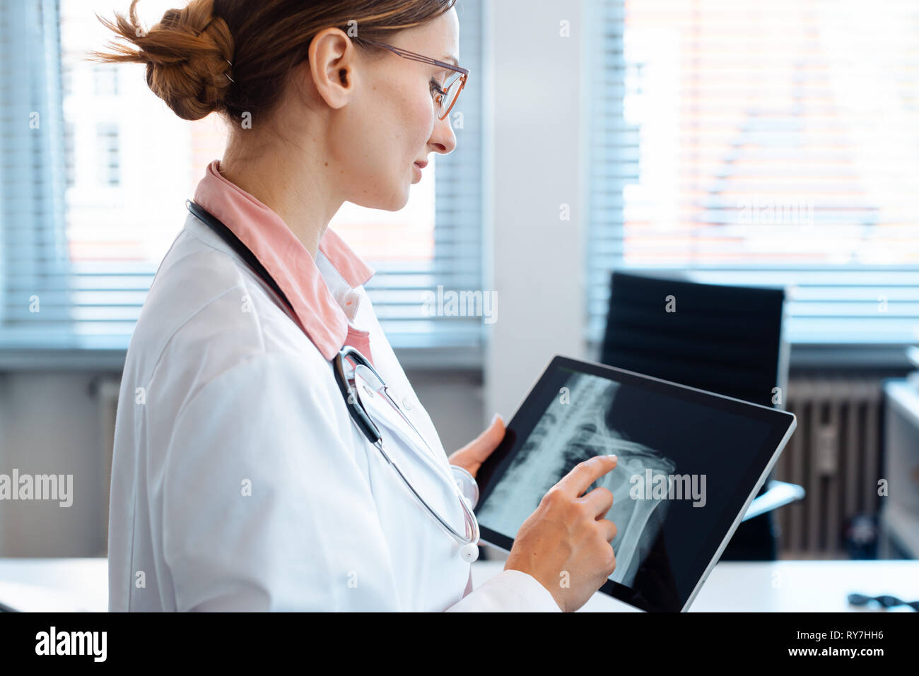 Doctor looking at x-ray picture of a shoulder on her tablet computer Stock Photo