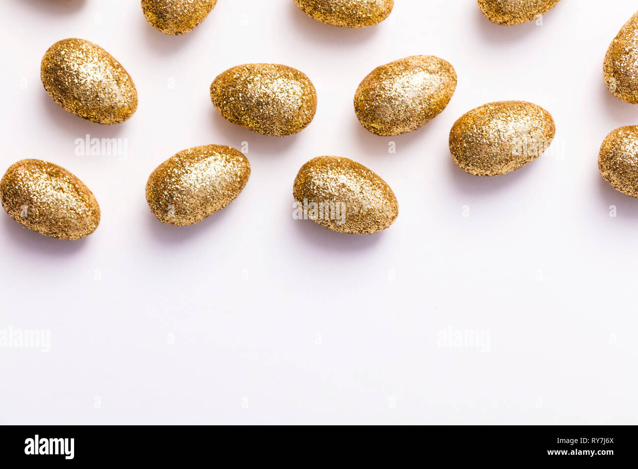 Gold glitter easter eggs on a plain white background Stock Photo