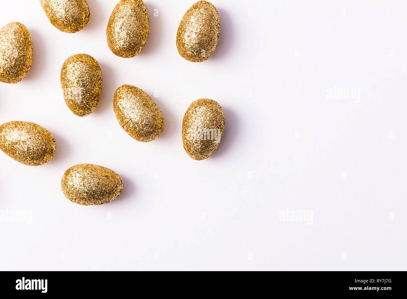Gold glitter easter eggs on a plain white background Stock Photo