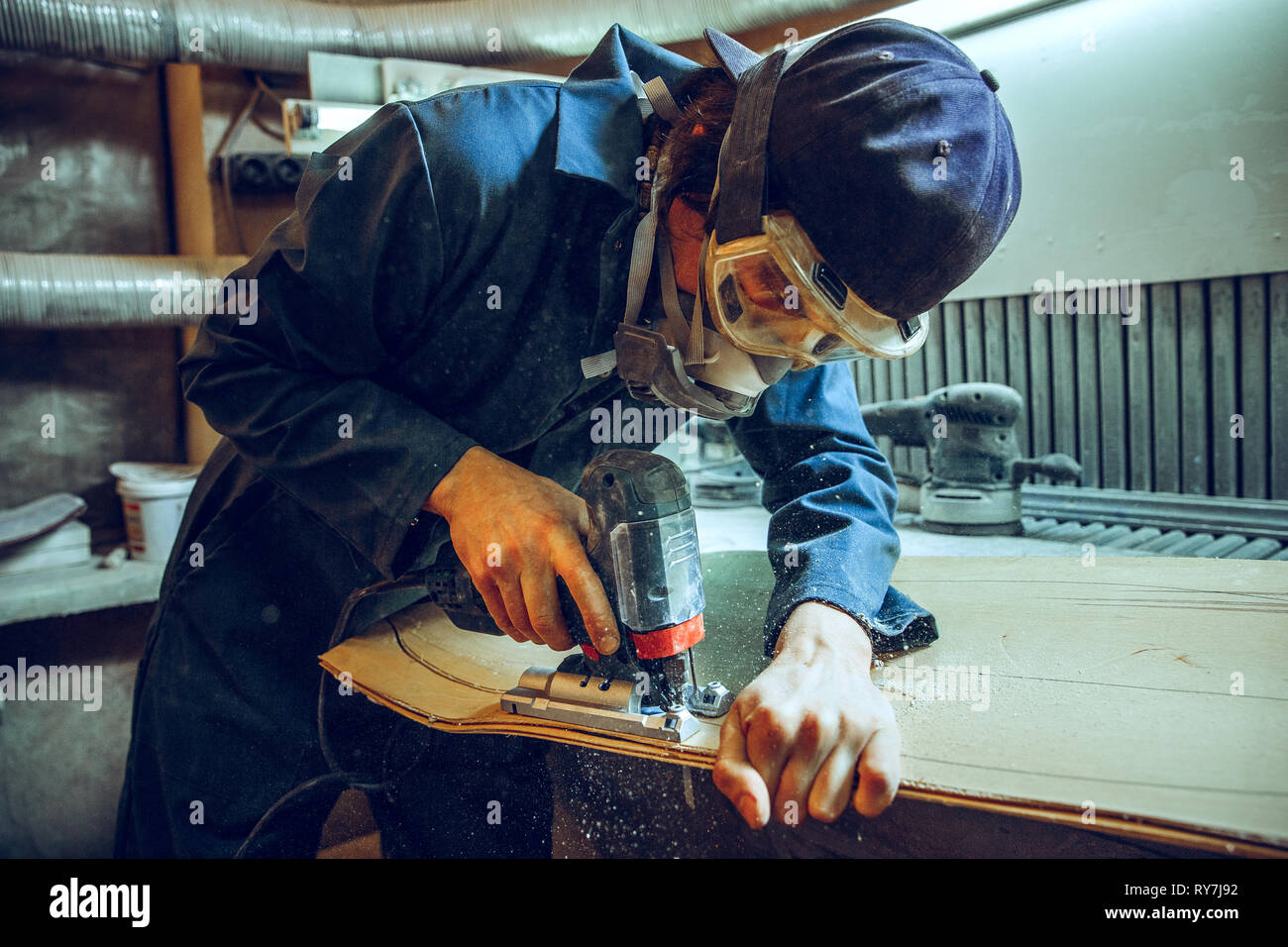 Carpenter using circular saw for cutting wooden boards. Construction details of male worker or handy man with power tools Stock Photo